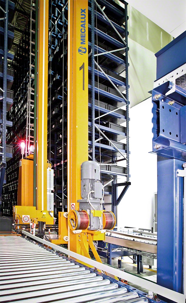 A miniload stacker crane runs through the aisle in charge of inserting and extracting the goods in their locations automatically