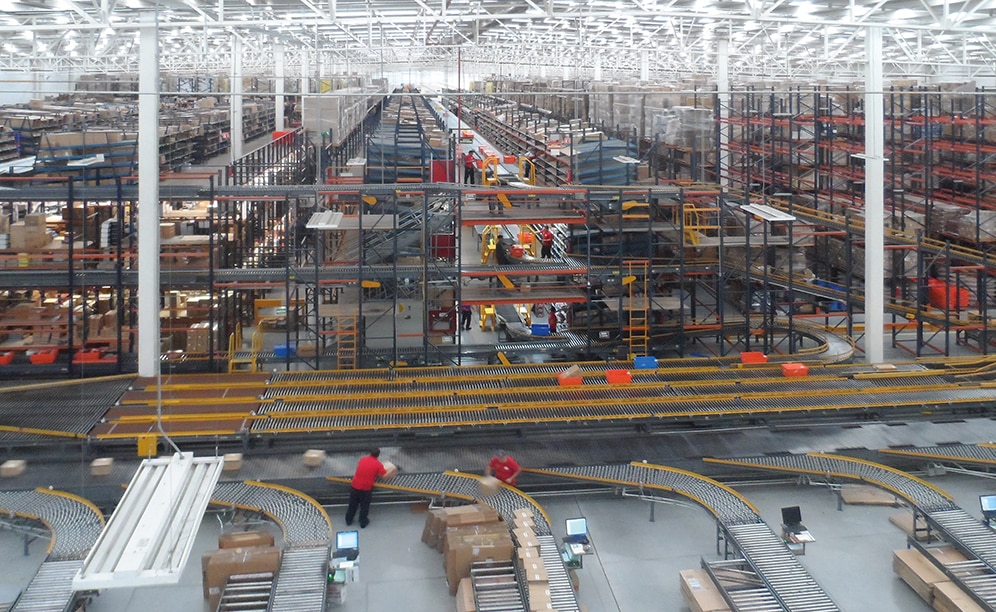 An enormous automated sorter with eight chutes categorises the boxed orders from the picking block
