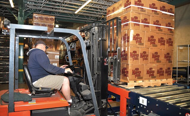 For entry into the AS/RS pallet racking, lift trucks transport pallet loads to an induction station conveyor