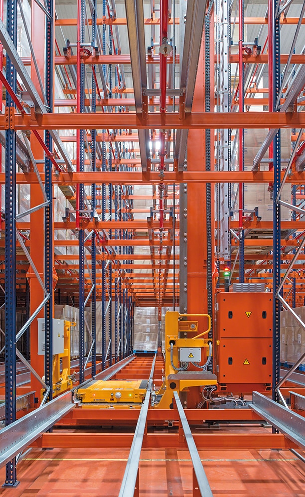A twin-mast stacker crane circulates in each aisle that carries a Pallet Shuttle in its cradle